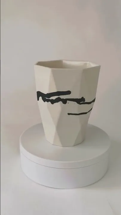 Video of a black and white porcelain vase turning on a plinth