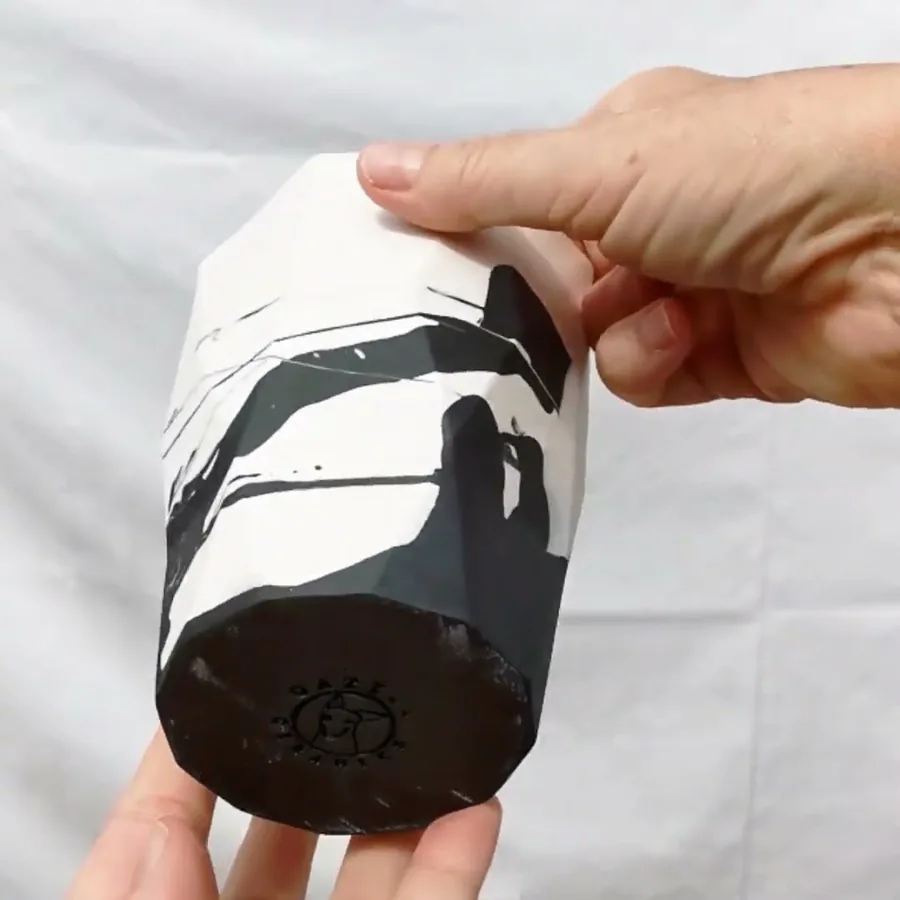 Video of a hand turning a black and white ceramic vase